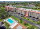 Aerial view of a community featuring a pool, well-manicured landscaping, and ample parking at 9450 Harbor Greens Way # 403, Seminole, FL 33776