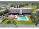 Aerial view of a condo complex featuring a pool, clubhouse, and parking area at 9450 Harbor Greens Way # 403, Seminole, FL 33776