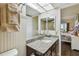Bathroom with brown vanity, granite countertop, and shower with glass doors, plus view into main bedroom at 9450 Harbor Greens Way # 403, Seminole, FL 33776