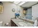 Cozy bathroom featuring granite countertop, updated fixtures, and nautical themed decor at 9450 Harbor Greens Way # 403, Seminole, FL 33776