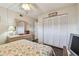 Bedroom with ceiling fan, wood floors, dresser, closet, and TV, with neutral walls and decor at 9450 Harbor Greens Way # 403, Seminole, FL 33776