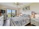 Light-filled bedroom with ceiling fan, wood floors and sliding glass doors that open to the screened-in lanai at 9450 Harbor Greens Way # 403, Seminole, FL 33776