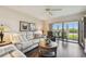 Comfortable living room with hardwood floors, white sofa, and access to screened balcony at 9450 Harbor Greens Way # 403, Seminole, FL 33776