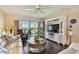 Comfortable living room featuring entertainment center, hardwood floors, and view of the water at 9450 Harbor Greens Way # 403, Seminole, FL 33776