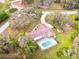 An aerial view of a single-Gathering home showing the pool, surrounding trees, and long driveway at 10206 Lakeview Dr, New Port Richey, FL 34654