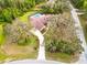 A sprawling single-Gathering home features mature landscaping, a long driveway, and an in-ground pool with screened enclosure at 10206 Lakeview Dr, New Port Richey, FL 34654