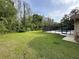 The spacious backyard has a lush lawn, a swimming pool, and a view of the forest at 10206 Lakeview Dr, New Port Richey, FL 34654