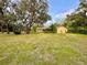 Sprawling backyard surrounded by mature trees offering privacy, with a detached shed at 10206 Lakeview Dr, New Port Richey, FL 34654
