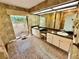 Bathroom features double sink vanity, large mirror, tiled floor, and decorative wallpaper at 10206 Lakeview Dr, New Port Richey, FL 34654
