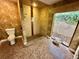 Bathroom with a tiled shower, toilet, patterned tile floor and natural light from a garden window at 10206 Lakeview Dr, New Port Richey, FL 34654