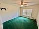 Bedroom featuring green carpet, ceiling fan and a window at 10206 Lakeview Dr, New Port Richey, FL 34654
