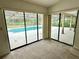Bedroom featuring large windows with views of the screened-in pool and patio at 10206 Lakeview Dr, New Port Richey, FL 34654
