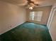 Bedroom featuring green carpet, ceiling fan and a window at 10206 Lakeview Dr, New Port Richey, FL 34654