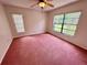Bedroom with pink carpeting, two windows, and ceiling fan at 10206 Lakeview Dr, New Port Richey, FL 34654