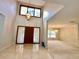 Bright foyer with high ceilings, a modern chandelier, tile flooring, and a dark wood front door at 10206 Lakeview Dr, New Port Richey, FL 34654