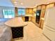 Updated kitchen featuring wood cabinets, black appliances, granite countertops, and tile flooring at 10206 Lakeview Dr, New Port Richey, FL 34654