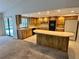 Bright kitchen with wood cabinets, brick accent wall, breakfast bar, and an adjacent living area and sliding glass doors at 10206 Lakeview Dr, New Port Richey, FL 34654