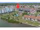 Aerial view of a condo building with pool, palm trees, and waterfront access, highlighting community amenities at 10215 Regal Dr # 21, Largo, FL 33774