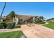 Community clubhouse featuring stone facade, manicured landscaping and circular driveway at 10215 Regal Dr # 21, Largo, FL 33774