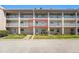 Exterior view of a three-story condo building with white railings and well-maintained landscaping at 10215 Regal Dr # 21, Largo, FL 33774