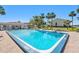 Large community pool with lounge chairs and manicured lawn at 10215 Regal Dr # 21, Largo, FL 33774