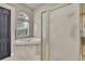 Bright bathroom featuring a corner tub with tile surround and enclosed glass door shower at 10322 Riverburn Dr, Tampa, FL 33647