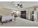 Well-lit bedroom with a ceiling fan, large TV, shoe racks, and neutral-toned walls at 10322 Riverburn Dr, Tampa, FL 33647