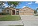 Charming single-story home featuring a three-car garage, manicured lawn, and inviting front entrance at 10322 Riverburn Dr, Tampa, FL 33647