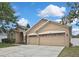 Exterior view of the home showing the three-car garage and well-kept lawn at 10322 Riverburn Dr, Tampa, FL 33647