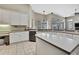 Bright open concept kitchen featuring white cabinets, stainless appliances, and tiled floors at 10322 Riverburn Dr, Tampa, FL 33647