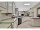 Open concept kitchen featuring white cabinets, stainless steel appliances, and tile flooring at 10322 Riverburn Dr, Tampa, FL 33647