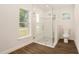 Bathroom featuring a glass walk-in shower, hardwood floors, and a window at 106 Ne 1St Ave, Lutz, FL 33549