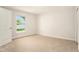 Carpeted bedroom featuring a window, an open door, and a closet at 106 Ne 1St Ave, Lutz, FL 33549