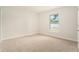 Bright, carpeted bedroom offers a clean, blank canvas with natural light from its window at 106 Ne 1St Ave, Lutz, FL 33549