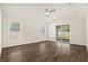 Bright bedroom with hardwood floors, ceiling fan, and sliding glass doors to backyard at 106 Ne 1St Ave, Lutz, FL 33549