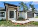 Inviting exterior with manicured landscaping, a two-car garage and a black double door entrance at 106 Ne 1St Ave, Lutz, FL 33549