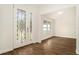 Bright foyer featuring decorative glass doors and stylish hardwood floors, leading to an open living space at 106 Ne 1St Ave, Lutz, FL 33549