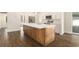Close up view of the kitchen island featuring quartz countertops, wood cabinets, and stainless sink at 106 Ne 1St Ave, Lutz, FL 33549