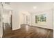 Bright living room with wood floors, decorative front door, and view into modern kitchen at 106 Ne 1St Ave, Lutz, FL 33549