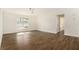 Spacious living room with hardwood floors, natural light from the window, and white walls at 106 Ne 1St Ave, Lutz, FL 33549