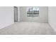 Bright bedroom featuring soft gray carpet and natural light from the window at 11717 Blackbrook Ct, Seffner, FL 33584