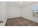 Minimalist bedroom features carpet and a window, providing a simple and functional living space at 11841 Thicket Wood Dr, Riverview, FL 33579