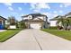 Two-story home with a two-car garage, solar panels, and a well-maintained lawn in a suburban neighborhood at 11841 Thicket Wood Dr, Riverview, FL 33579