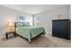 Inviting bedroom with a plush green comforter, a stylish side table lamp, and a minimalist aesthetic at 11854 Lake Lucaya Dr, Riverview, FL 33579