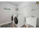 Bright laundry room with modern washer and dryer, utility sink, and ample shelving at 11854 Lake Lucaya Dr, Riverview, FL 33579