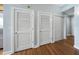 Hallway showcasing multiple white doors and hardwood floors, blending functionality with stylish design at 1208 E Kennedy Blvd # 1125, Tampa, FL 33602