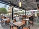 Inviting outdoor seating area with modern tables, chairs, and a stylish, covered structure with exposed steel beams and brick pavers at 1208 E Kennedy Blvd # 1125, Tampa, FL 33602
