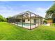 A large, screened pool and patio are overlooked by a lush lawn and landscaping at 12217 Snead Pl, Tampa, FL 33624