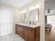 Bathroom featuring double vanity with marble floors, modern lighting, and large mirror at 12217 Snead Pl, Tampa, FL 33624