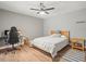 Cozy bedroom with wood flooring, a ceiling fan, and a gaming setup in a neutral color palette at 12217 Snead Pl, Tampa, FL 33624